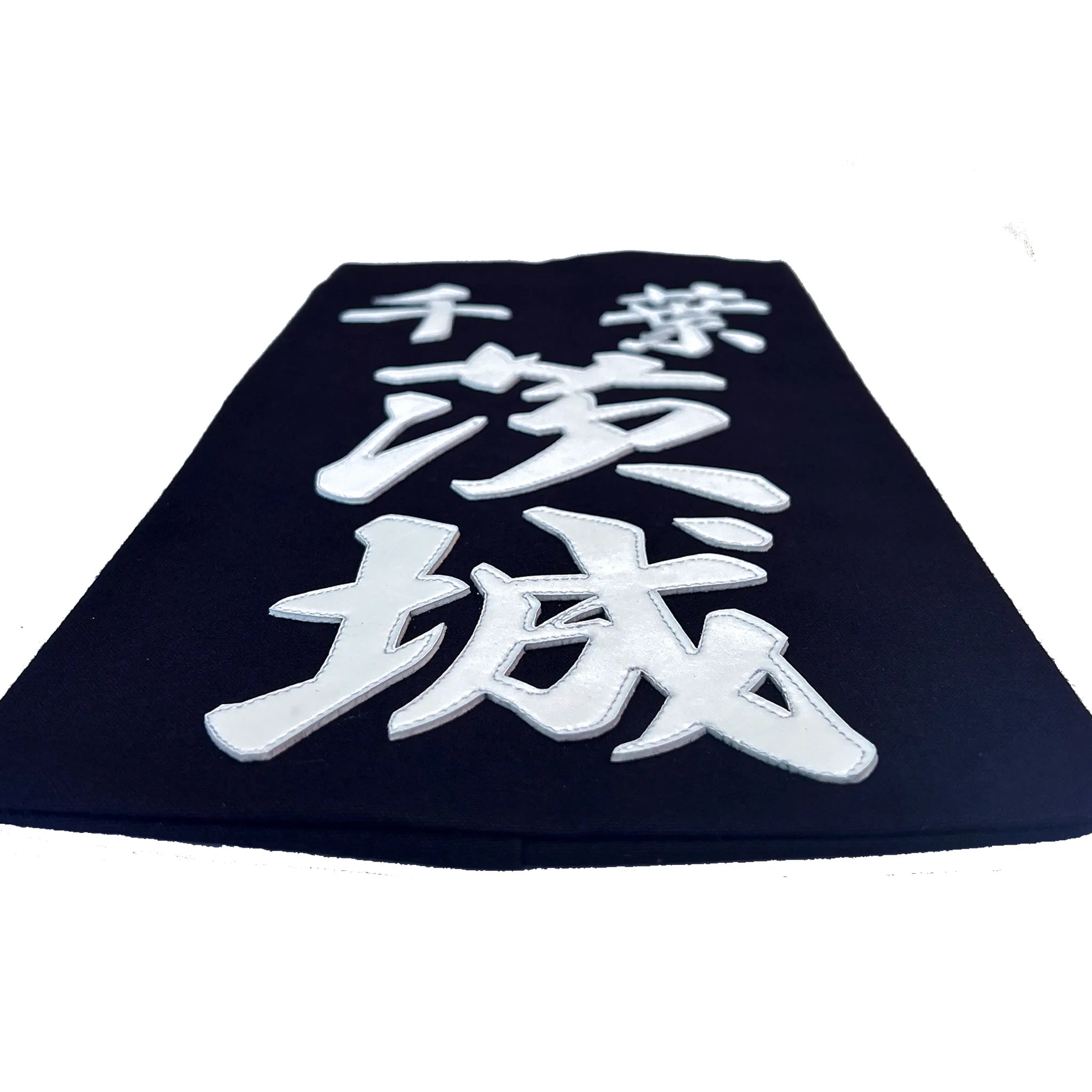 名札を机に置き、名札下側から水平気味に撮った構図。クラリーノで所属名、氏名を印字したことででる厚みが見える