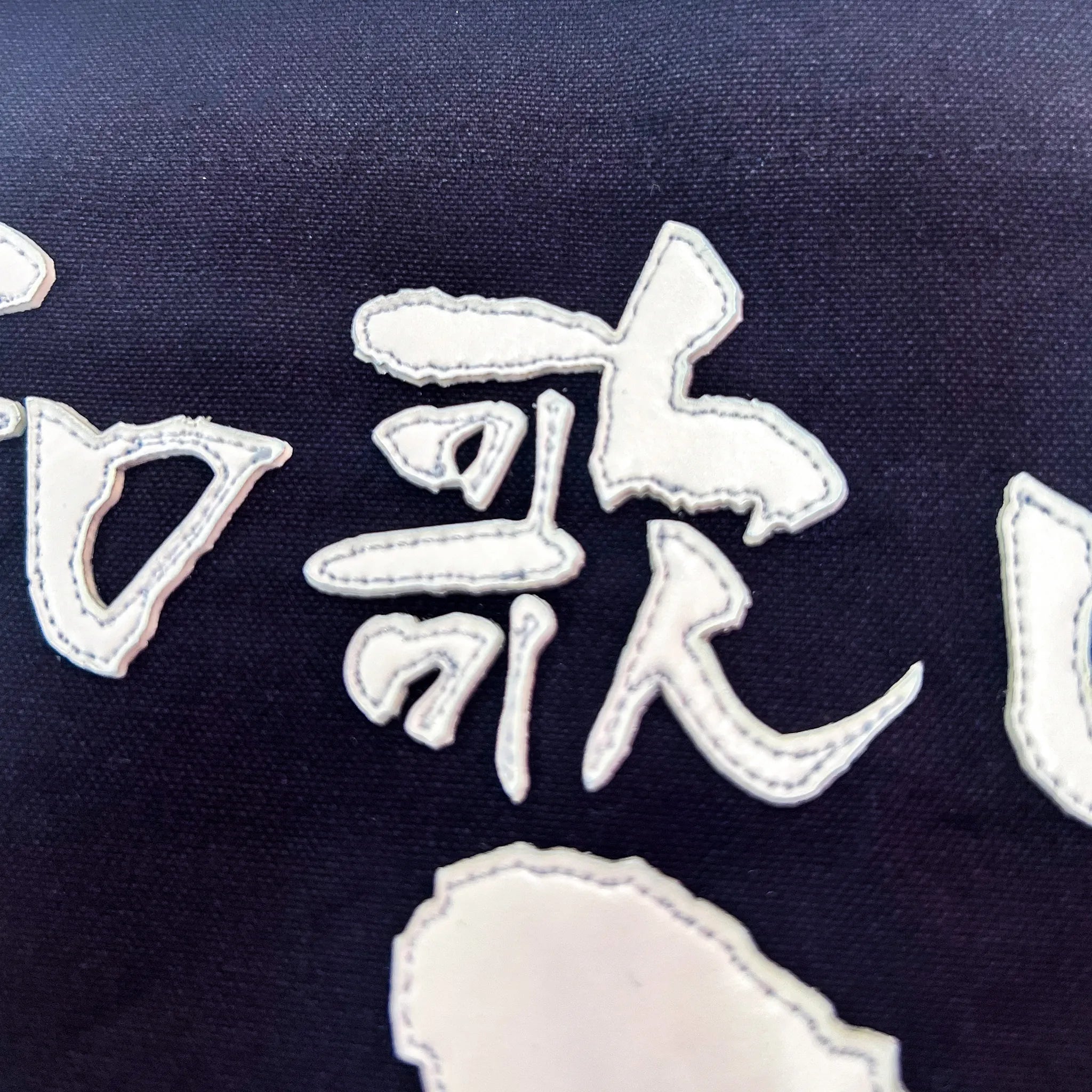 名札の文字のアップ写真。まどか書体の特徴的な払い