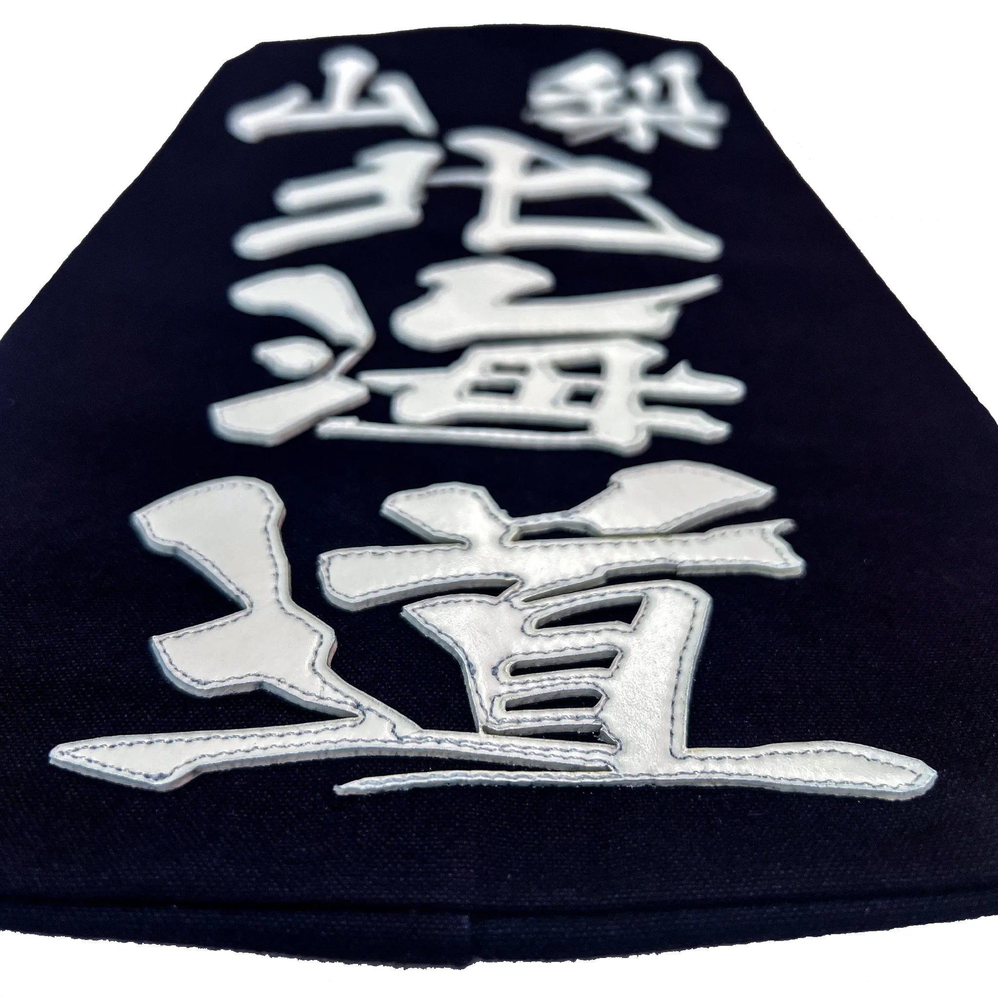 名札を机に置き、名札下側から水平気味に撮った構図。クラリーノで所属名、氏名を印字したことででる厚みが見える。