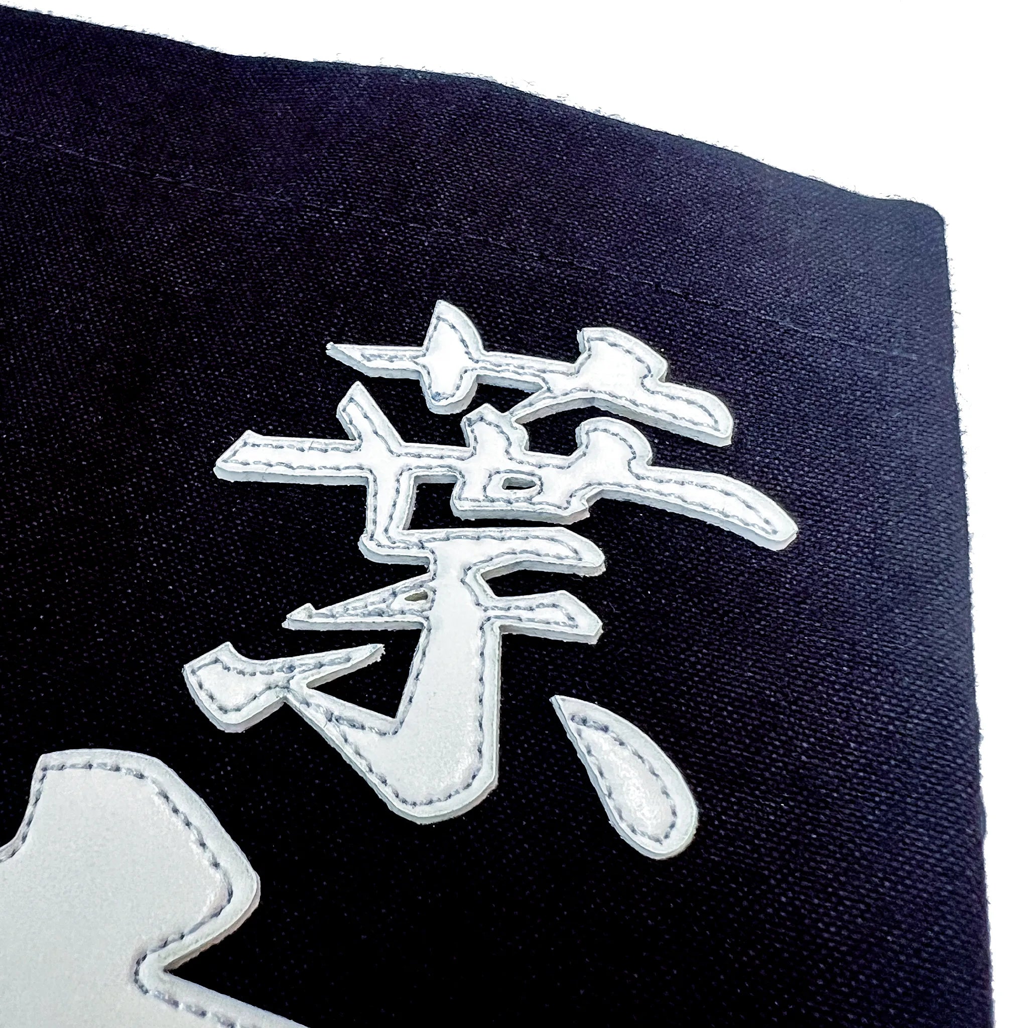 名札の文字のアップ写真。行書の特徴的な払い