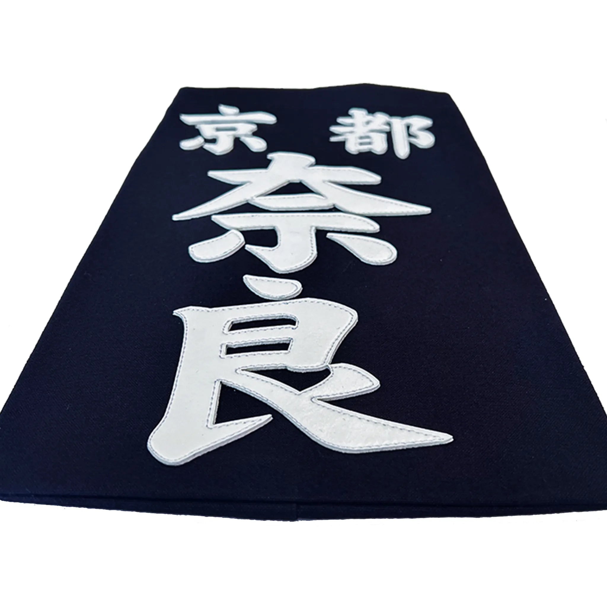 名札を机に置き、名札下側から水平気味に撮った構図。クラリーノで所属名、氏名を印字したことででる厚みが見える