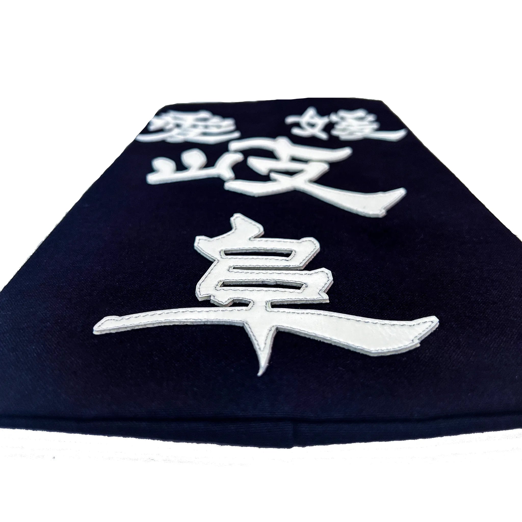 名札を机に置き、名札下側から水平気味に撮った構図。クラリーノで所属名、氏名を印字したことででる厚みが見える