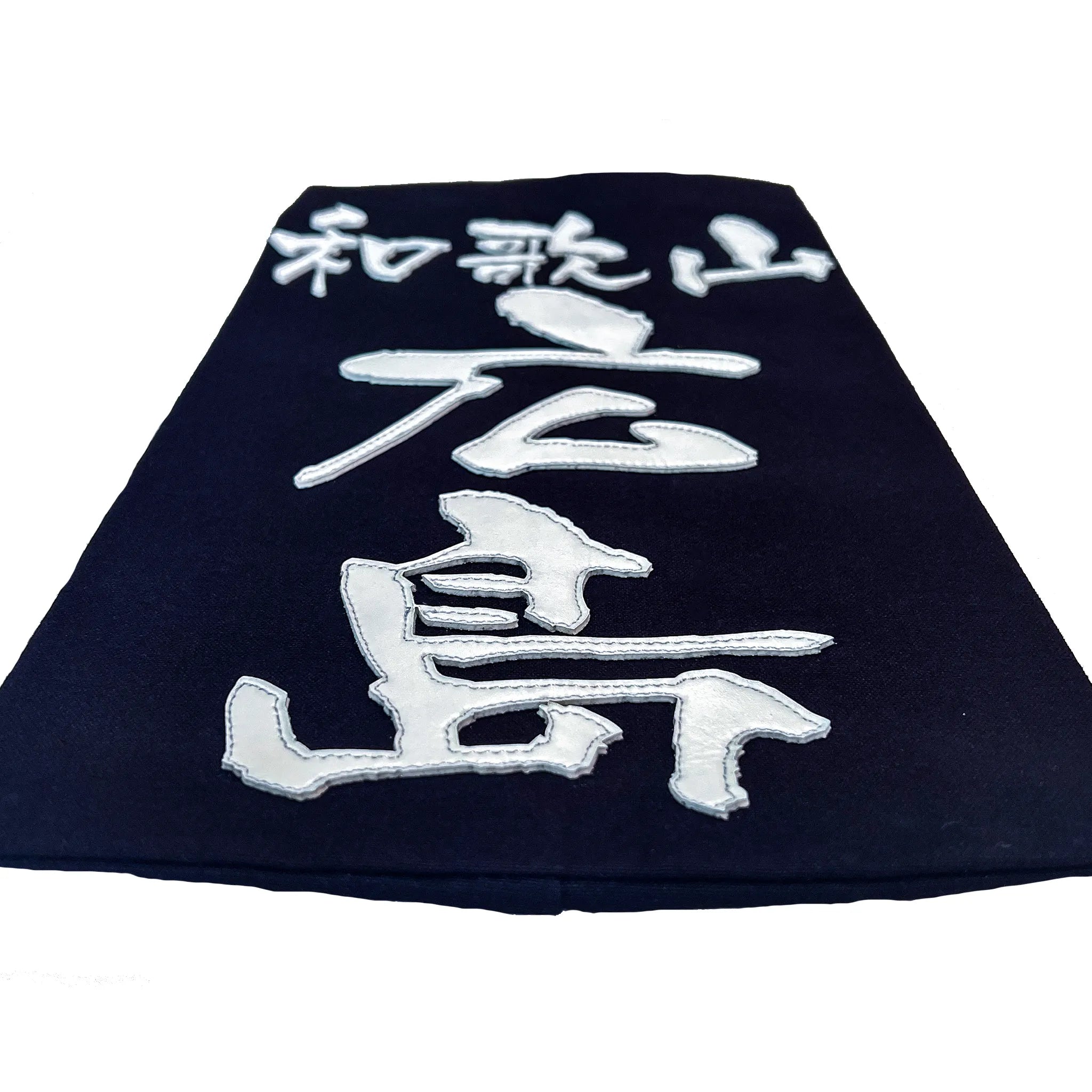 名札を机に置き、名札下側から水平気味に撮った構図。クラリーノで所属名、氏名を印字したことででる厚みが見える