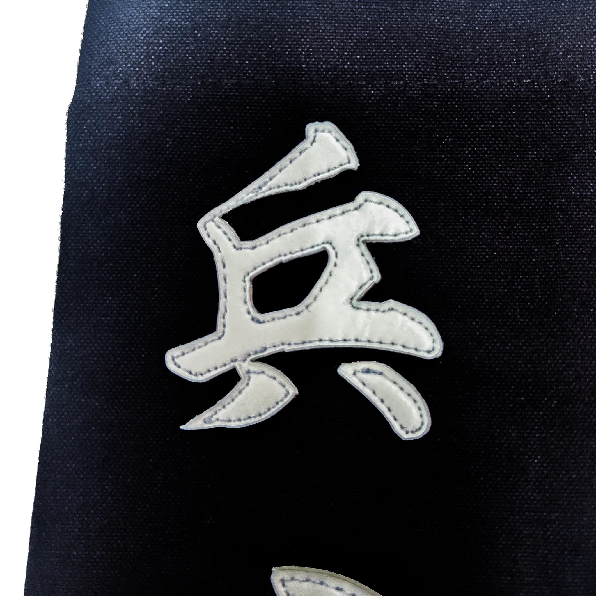 名札の文字のアップ写真。雲龍書体の伸びやかな点。